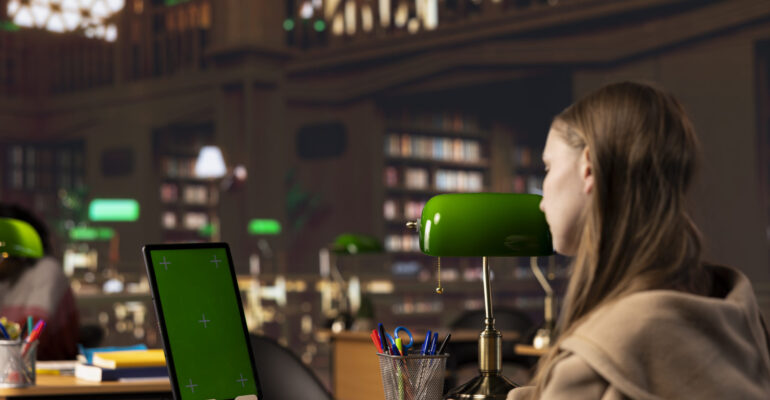 College student looks at a copy space screen on tablet while collecting notes